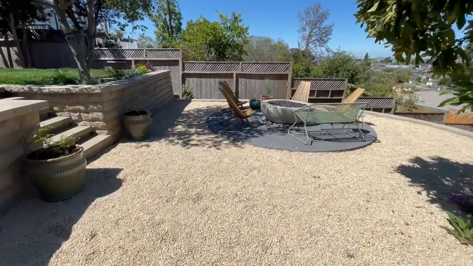 Gravel terrace with a fire pit surrounded by block retaining walls