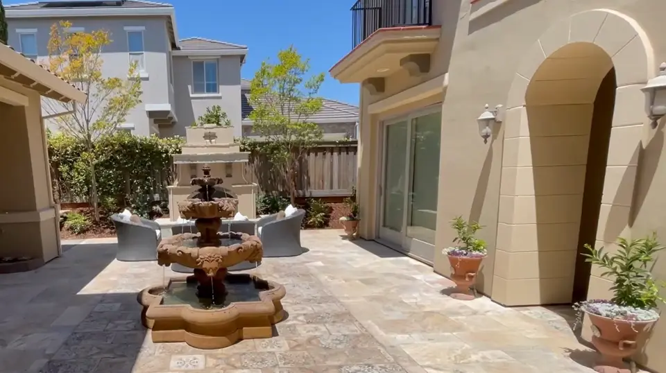 Front courtyard finished in decorative stamped concrete with a tiered fountain