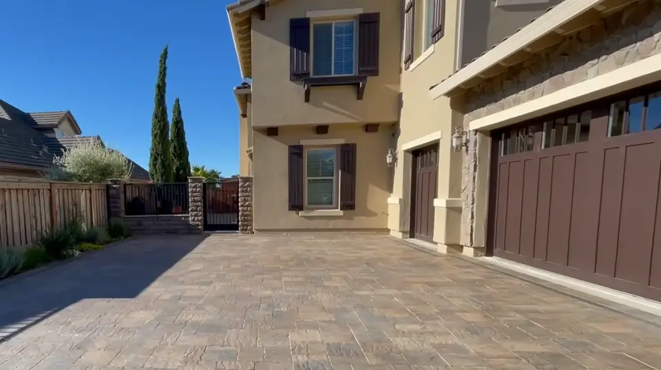 Finished stamped concrete driveway and side yard beside a two-story home